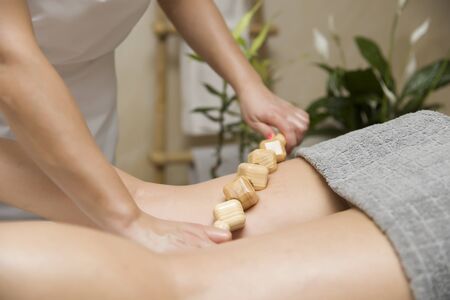 Closeup of the maderotherapy anti-cellulite massage with wooden roller massagerの写真素材