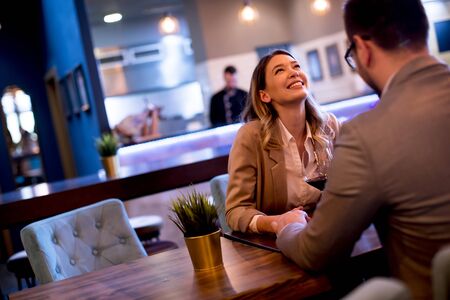 Young couple enjoying lunch in the restaurant with glasses of red wineの写真素材