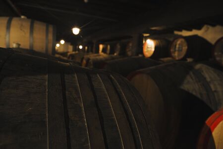 View at wine in wooden barrels stored for aging in the cellarの写真素材