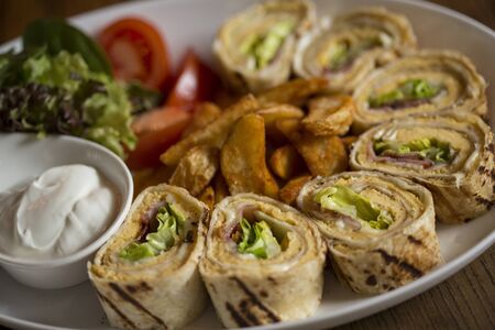 Freshly made omelette rolls in the plate on the tableの写真素材