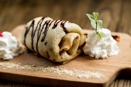 Freshly made pancake roll on the wooden plateの写真素材