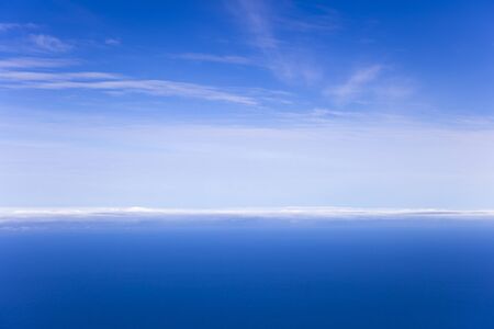 Calm blue sea and sky horizon with cloudsの写真素材