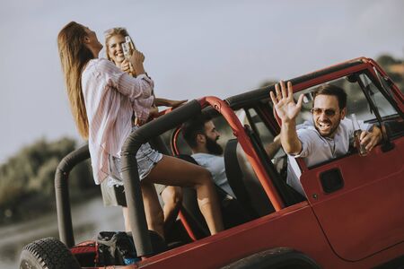 Group of happy young people enjoying road tripの写真素材