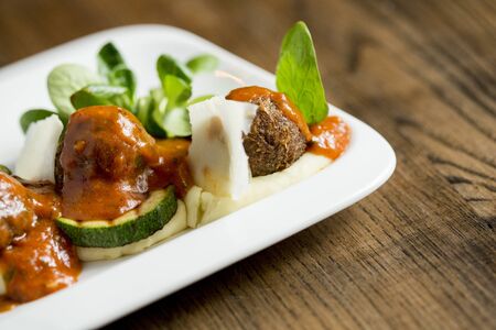 Meatballs with tomato sauce and cucumbers on the plate