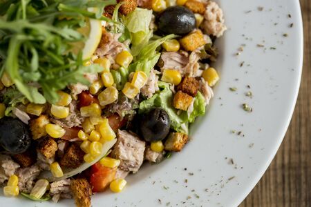 Tun salad with olives, corn and rocket on the tableの写真素材