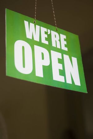 Open sign on the glass of the door at the store