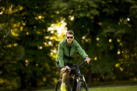 Handsome young man riding ebike in natureの写真素材