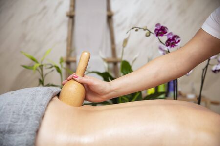 Woman having back maderotherapy massage with wooden swedish cupの写真素材