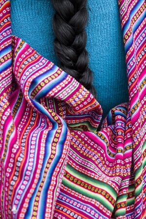 Closeup of Peruvian woman with the long black hair braids, wearing traditional colorful clothes in Lima, Peruの写真素材
