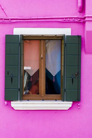 Old traditional window on the colorful facade of building in Burano island, Italyの写真素材
