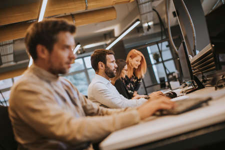 Handsome young professional businessman uses a computer for work in the modern office