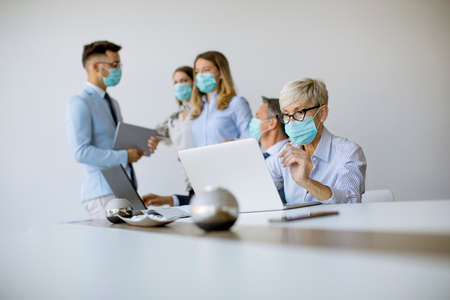 Group of business people have a meeting and working in the office and wear masks as protection from...