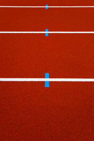 Closeup of the white lines on red stadium running trackの写真素材