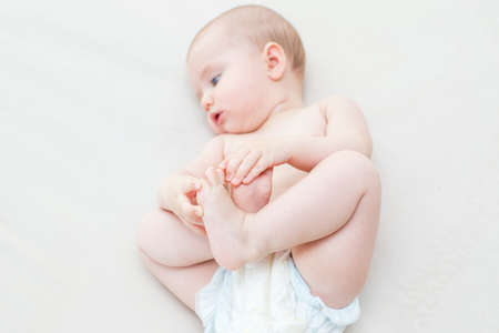 Cute adorable baby girl lying on the bedの写真素材