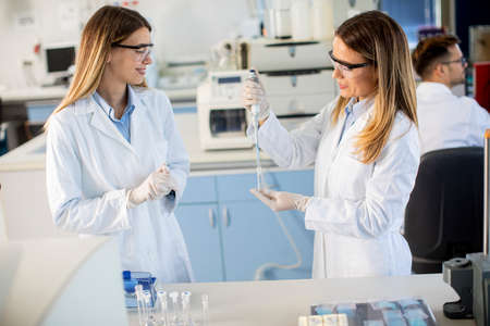 Cute female researchers in white lab coat working in the laboratoryの写真素材