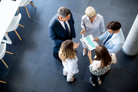 Over view at group of businesspeople standing in the office and analyzing planの写真素材