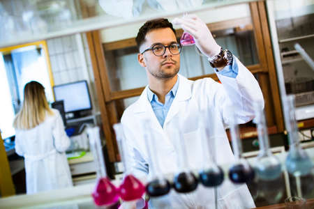 Young researcher checking test tubes in the laboratory