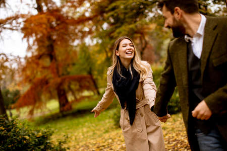 Handsome young couple walking in the autumn parkの写真素材