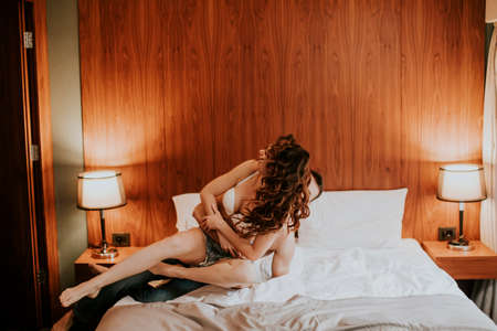 Handsome young man and pretty young woman having fun in the bedの写真素材