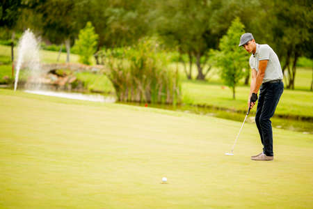 Handsome young man playing golf