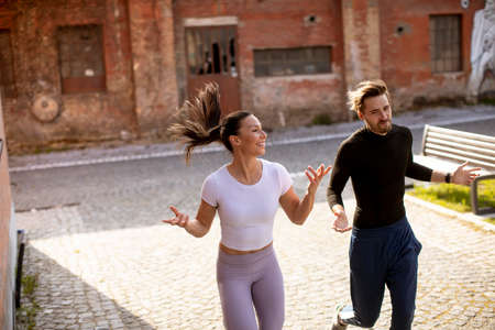 Handsome young fitness couple running in urban areaの写真素材