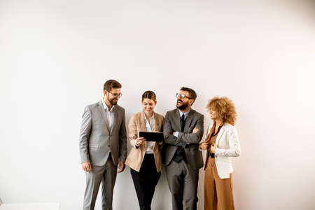 Multiethnic business people using digital tablet while standing by the wall in the modern officeの写真素材