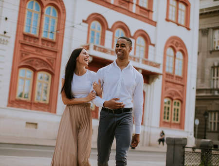 Handsome young multiethnic couple walking on the street