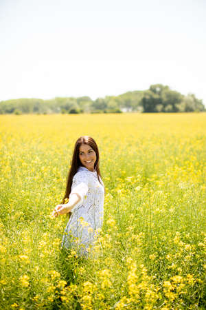 Pretty young woman in the rapeseed fieldの写真素材