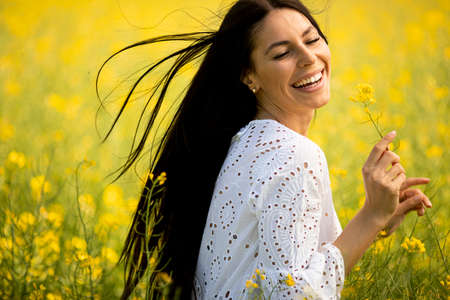 Pretty young woman in the rapeseed field