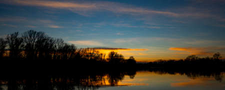 View at sunset on the calm lake