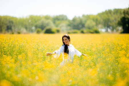 Pretty young woman in the rapeseed fieldの写真素材