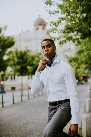 Handsome young African American businessman waitng a taxi on a streetの写真素材