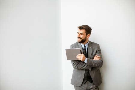 Handsome young modern businessman using digital tablet in the office