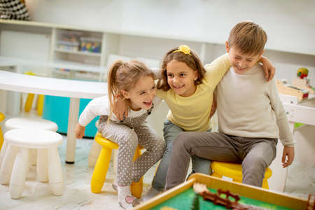 Group of cute kindergarten kid friends sitting and having fun