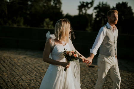 Closeup of the cute young newlywed couple walking in the parkの写真素材