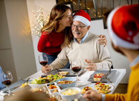 Happy family celebrating New Year by the table at homeの写真素材