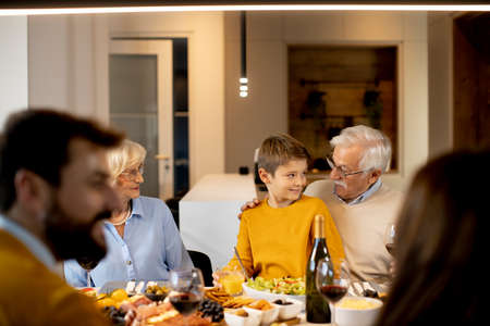 Happy family having a dinner with red wine at home