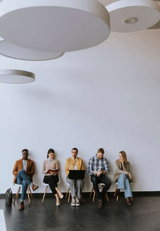 Group of bored young people waiting for the job interviewの写真素材