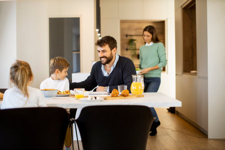 Young mother preparing breakfast for her family in the modern kitchenの写真素材