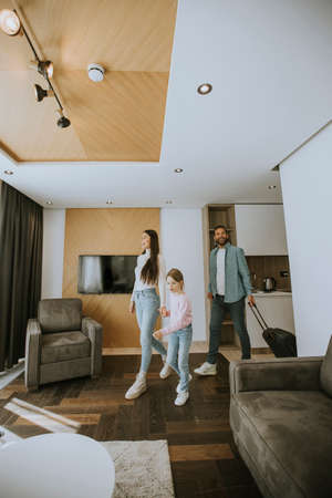 Happy young family arrive into hotel roomの写真素材