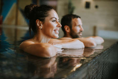 Handsome youple relaxing in a indoor swimming poolの写真素材