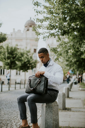 Handsome young African American businessman waitng for a taxi waitng a taxi on a streetの写真素材