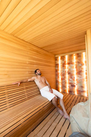 Handsome young man relaxing in the saunaの写真素材