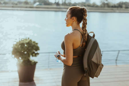 Pretty young woman takes a break after running in the urban areaの写真素材