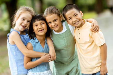 Group of cute asian and caucasian kids having fun in the park