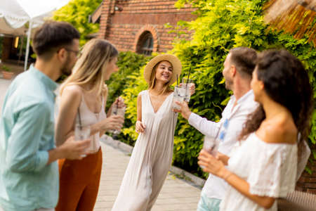 Group of happy young people cheering and having fun outdoors with drinksの写真素材