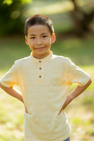 Cute little Korean boy standing in the park on a sunny dayの写真素材