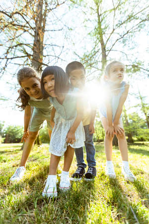 Group of cute asian and caucasian kids having fun in the park