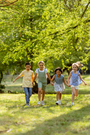 Group of cute asian and caucasian kids having fun in the park