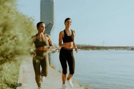 Pretty young woman taking running exercise by the river promenadeの写真素材